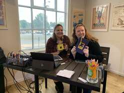 Two women sitting at table with IRC materials.